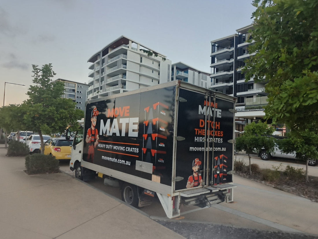 Move Mate truck parked on a city street with apartment buildings behind
