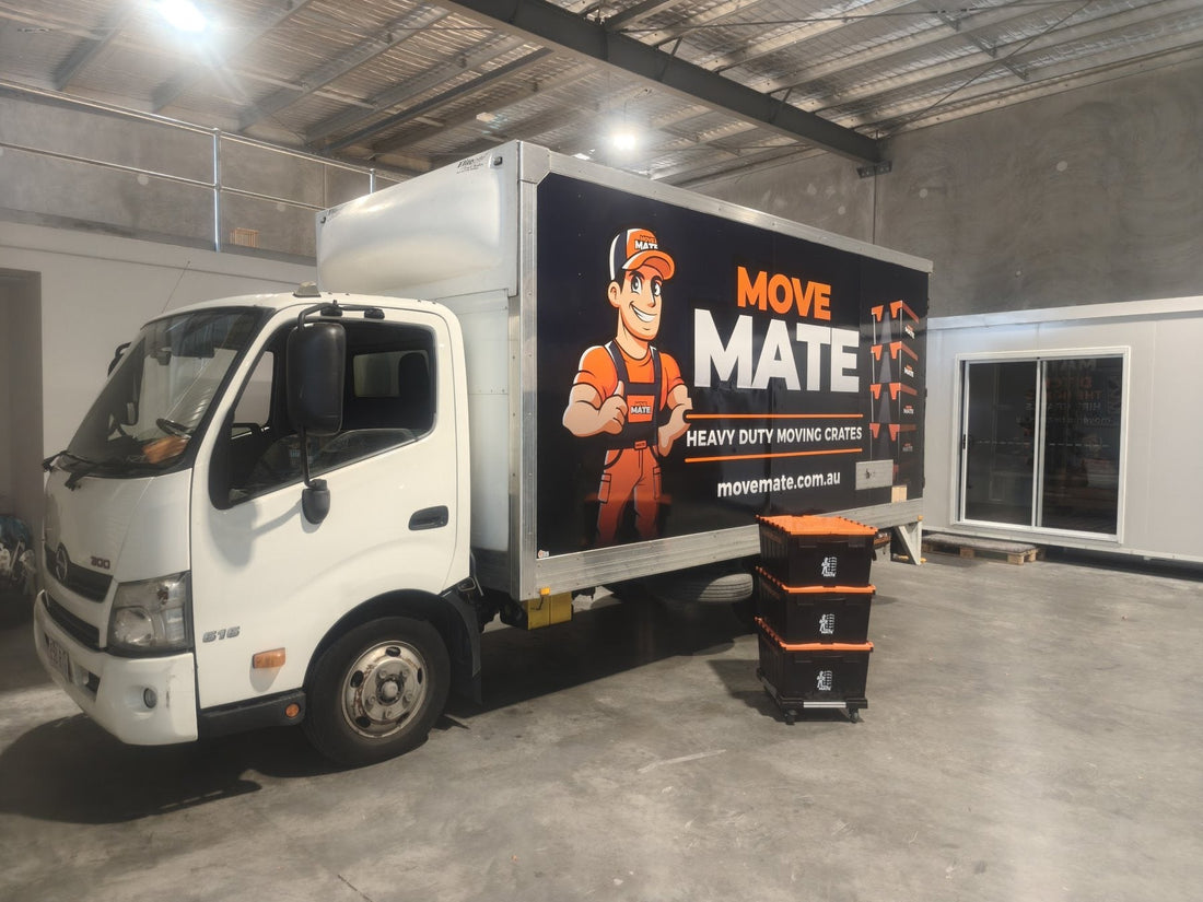Move Mate truck parked in a large shed with a stack of crates in front