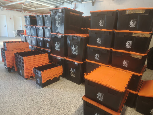 Neat stacks of black and orange Move Mate crates on a garage floor