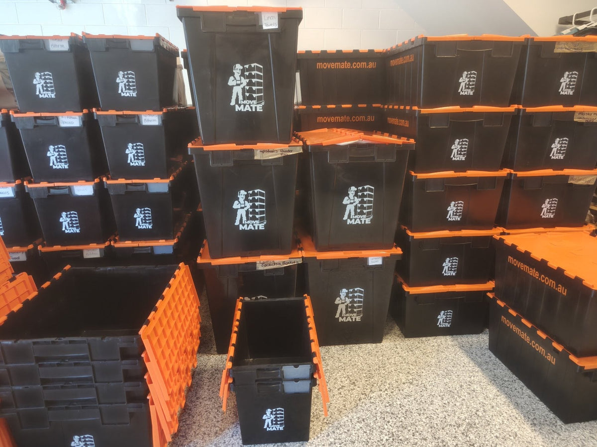 Rows of black Move Mate crates with orange lids stacked side by side